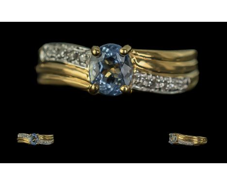 18ct Gold Ladies Dress Ring, twist style diamond set shoulders with a central blue stone.  Ring size M.