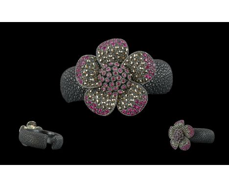 Black Embossed Bangle, set with a large flower decorated with pink Swarovski crystals.