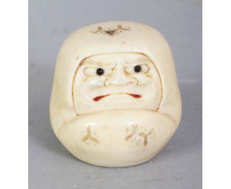 A SIGNED JAPANESE MEIJI PERIOD IVORY NETSUKE OF A DARUMA DOLL, with frowning expression, his mouth stained red, the base with