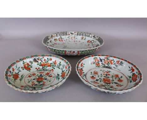 A PAIR OF CHINESE KANGXI PERIOD FAMILLE VERTE FLUTED PORCELAIN BOWLS, circa 1700, each painted with birds and arrangements of