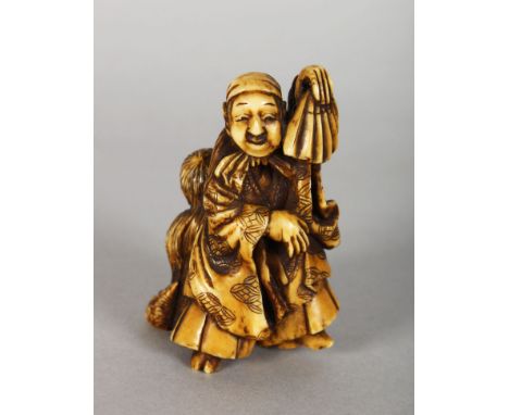 A JAPANESE MEIJI PERIOD STAINED IVORY NETSUKE OF A DANCER &amp; HIS SON, the man holding an upturned fan, 2.9in high.