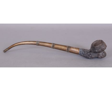 A 19TH/20TH CENTURY THAI OPIUM PIPE, with a moulded grey clay bowl and a banded metal stem, 10.5in long.