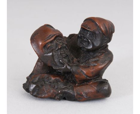 AN EARLY 20TH CENTURY JAPANESE CARVED WOOD NETSUKE OF A MASK MAKER, 1.25in high.