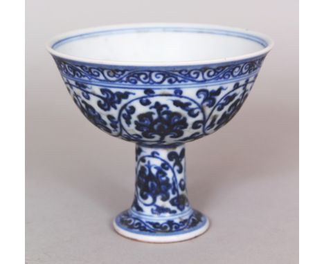 A CHINESE MING STYLE BLUE &amp; WHITE PORCELAIN STEM CUP, decorated with formal scrolling lotus within classic scroll borders