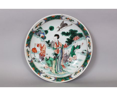 A CHINESE KANGXI STYLE FAMILLE VERTE PORCELAIN SAUCER DISH, decorated with a scene of a lady and boys in a fenced garden sett