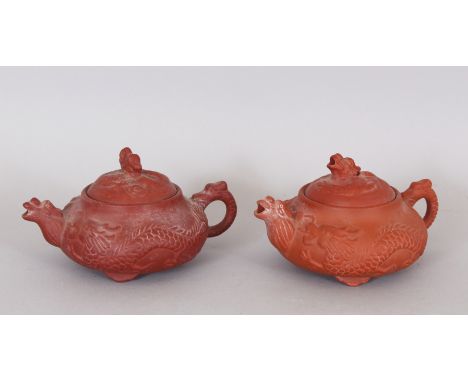 A GOOD PAIR OF 17TH/18TH CENTURY MOULDED ZISHA YIXING POTTERY TEAPOTS &amp; COVERS, circa 1690, the sides of each moulded wit