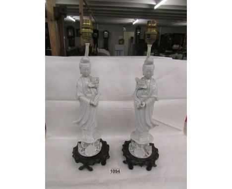 A pair of ceramic table lamps in the form of Chinese figures, need re-wiring.