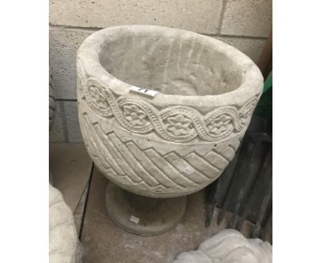 A Mayan circular planter decorated with aztec design