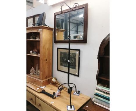 A wrought iron adjustable height lamp stand with tripod base but no shade