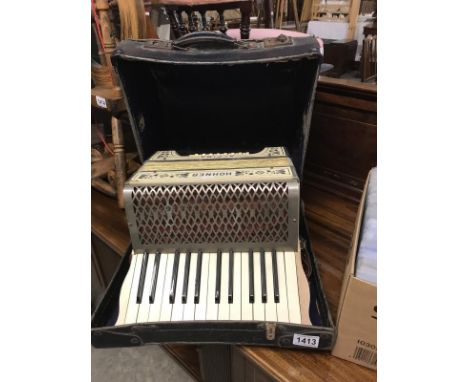 A cased Hohner piano accordion.