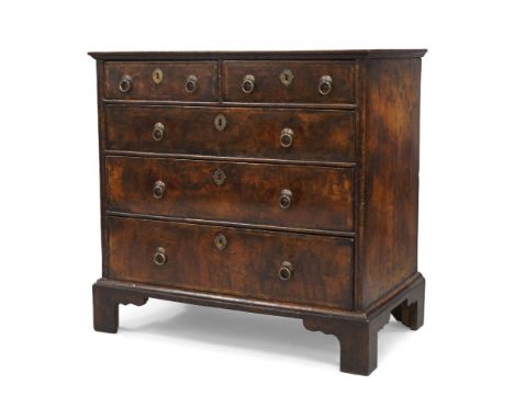 A George I walnut chest of drawers, circa 1720, mahogany crossbanded, with two short above three long drawers raised on brack