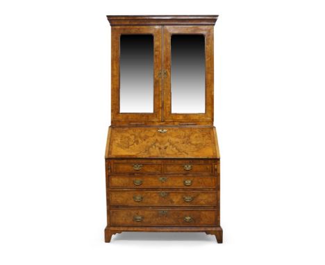 A George II figured walnut bureau bookcase, the moulded cornice above pair of mirrored doors, enclosing two adjustable shelve