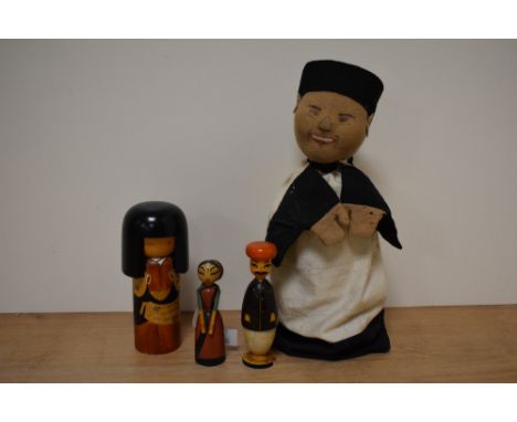 An early 20th century Oriental hand puppet and three wooden figures.