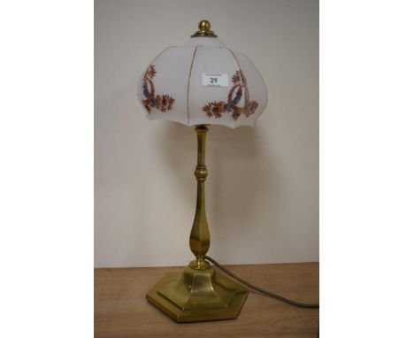 An early 20th century brass lamp, having opaque glass shade with flower and swag design.