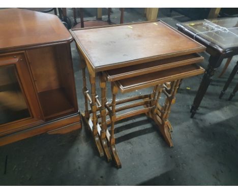 A nest of 3 light wood tables united by stretchers