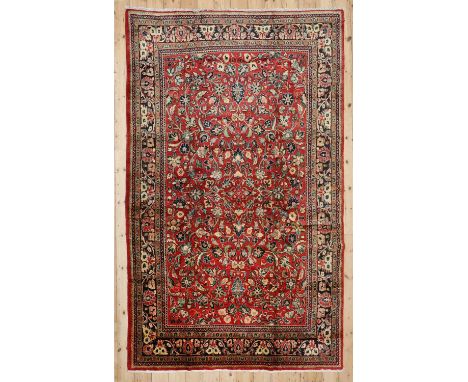 A Persian wool carpet, mid-20th century, Mahal, decorated with scrolling Shah Abbasi motifs on a red ground, 333 x 210 cmCond