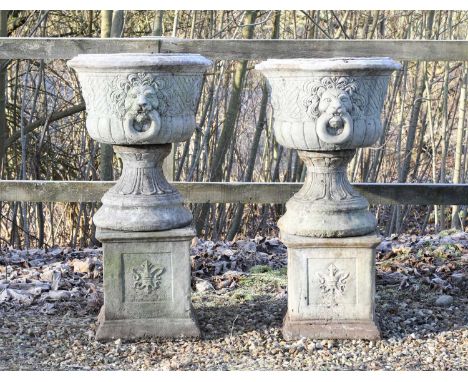 A pair of composite stone garden urns, late 20th century, in the Renaissance taste, each with relief-moulded lion mask detail