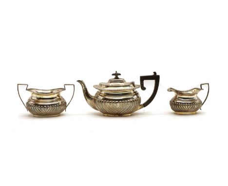 A composed three piece silver tea service, comprising a late Victorian teapot, 13cm high, an early 20th century cream jug and