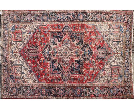 A Heriz carpet, with a large central medallion enclosed by geometric borders, 371 x 254cmCondition report: Faded in places an