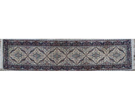 A hand knotted Persian runner, signed, decorated with six bordered medallions to a pale field, 390 x 82cmCondition report: An