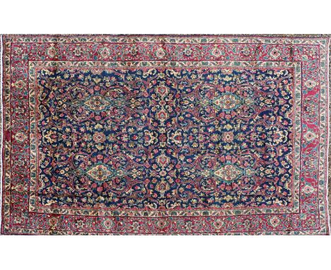 A Persian wool carpet, 20th century, Kashan, the navy field decorated with scrolling foliate Shah Abbasi motifs, 327 x 200 cm