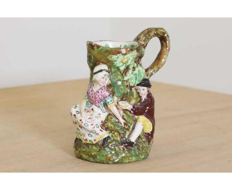 A Staffordshire pearlware 'Fair Hebe' jug, c.1710, moulded with a man handing a woman a bird's nest, at the base of a tree tr