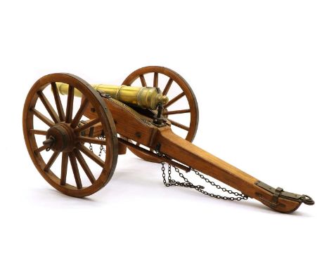 A model field canon, the brass barrel on wooden carriage with metal mounts and two ramroda and bucket. with crowned 'BP' proo