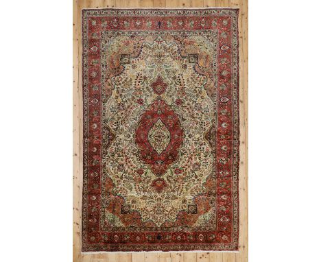 A Persian wool carpet, 20th century, Tabriz, the field woven with undulating medallions drawn with scrolling foliage, 305 x 2