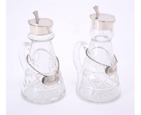 
	
		A pair of silver mounted tapering glass whiskey noggins by Walter Gardener Groves, London 1933, with a thumb piece to th