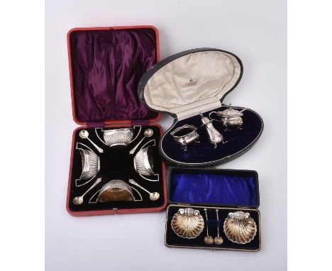 
	
		A cased pair of Edwardian silver shell shaped salts and spoons by Mitchell Bosley &amp; Co., Birmingham 1904, the salts 