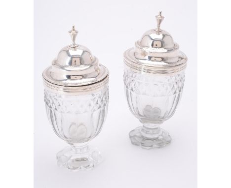 
	
		A pair of George III glass mustard jars with silver covers by Charles Chesterman II, London 1805, with urn shaped finial