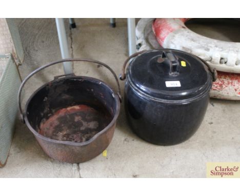 A black enamel cooking pot with lid and metal swing handle and a further cooking pot with swing handle