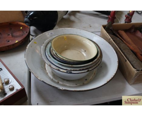 A large enamel pan and a quantity of enamel bowls