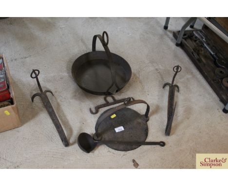 A pair of fireplace hangers, together with a 9" skillet, ladle, and an unusual pouring skillet