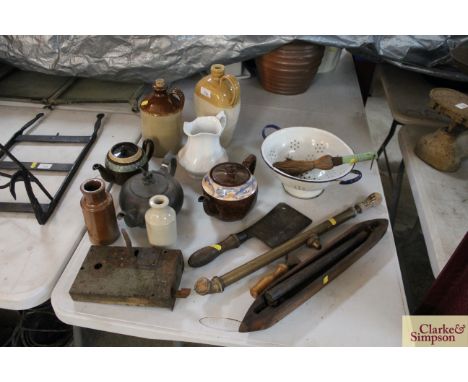 A collection of miscellaneous items to include a weaving shuttle, an old lock plate, an enamel colander, two stone glazed fla