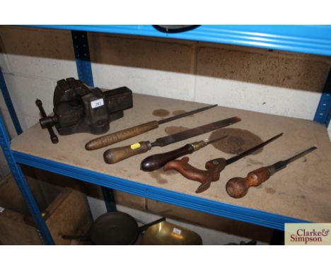 An iron bench vice; two rasps; two saws and a screwdriver