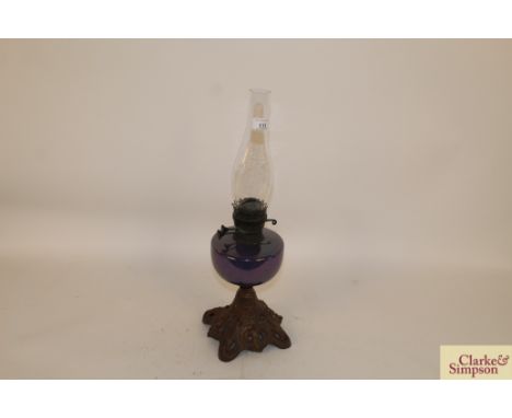 A Victorian oil lamp having pierced cast iron base and lustre ware reservoir 
