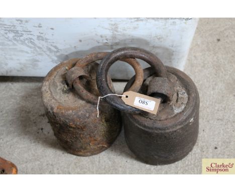 Two circular 56lb weights with ring handled tops 
