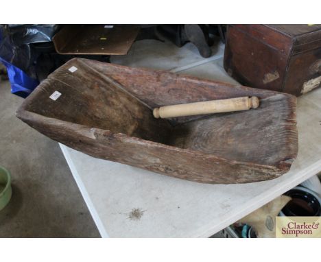 A large oblong dough kneading bowl and a rolling pin