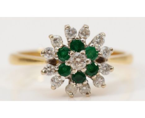 An 18ct gold brilliant cut diamond and emerald floral cluster ring, three tiered ring, middle tier consists of six emeralds, 