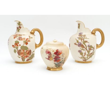 A pair of Royal Worcester pitchers, together with a lidded jar, decorated in blush ivory with a floral design and gilt highli