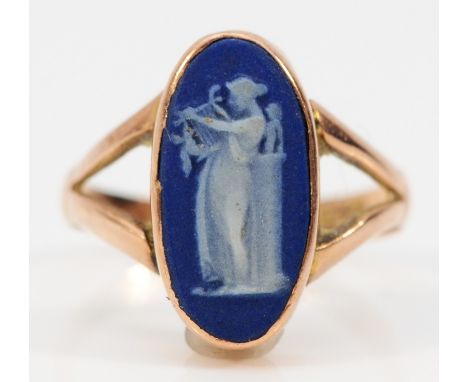 A 9ct rose gold Wedgwood blue jasperware ring depicting a woman playing a harp, split shoulders, Chester 1919, N, 2.3g