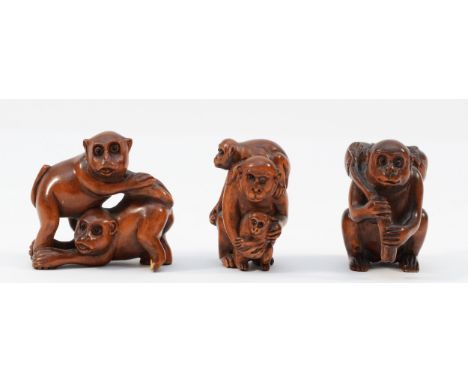 A Japanese hardwood netsuke of a monkey with two young, signed and two other similar (3).