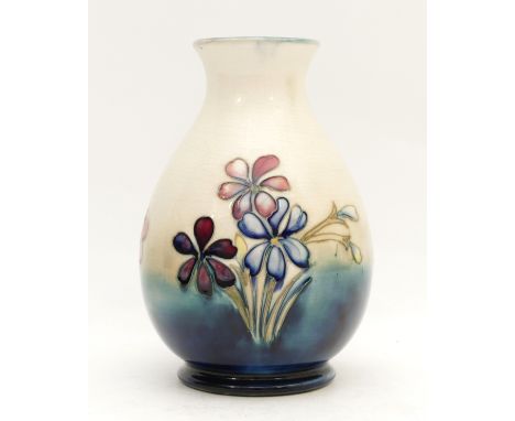 A Moorcroft vase, depicting spring flowers on mottled cobalt blue ground, manufactured between 1928 and 1949, complete with a