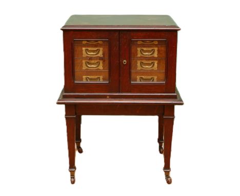 A late 19th century oak canteen side cabinet, the two glazed doors opening to a bank of four drawers with brass recessed hand