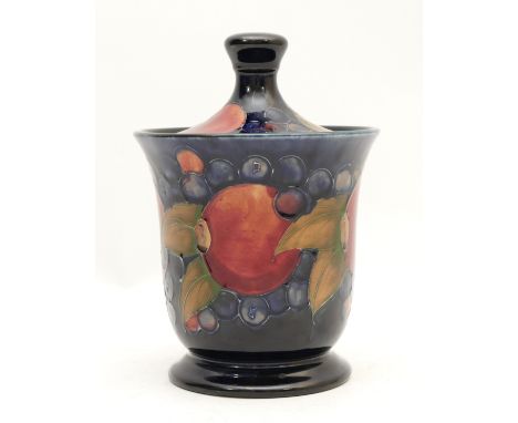 A Moorcroft jar with cover, in the pattern, 'Pomegranates', manufactured between 1947-53, with a Walter Moorcroft slate blue 