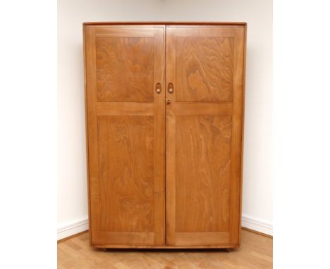 A 1960s Ercol light elm 'Windsor' double door compactum wardrobe, enclosed by two fielded doors, the interior with hanging ra