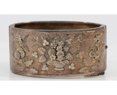 A Victorian silver hinged bangle, Birmingham 1884, the front with engraved and applied floral decoration, internally engraved