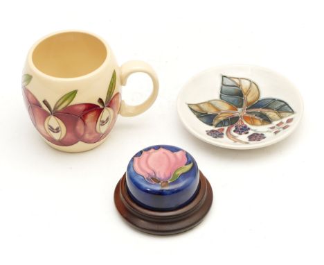 Three Moorcroft pieces, to include, a trinket dish entitled 'Bramble', dated 1992 with the candlestick emblem, a paperweight 