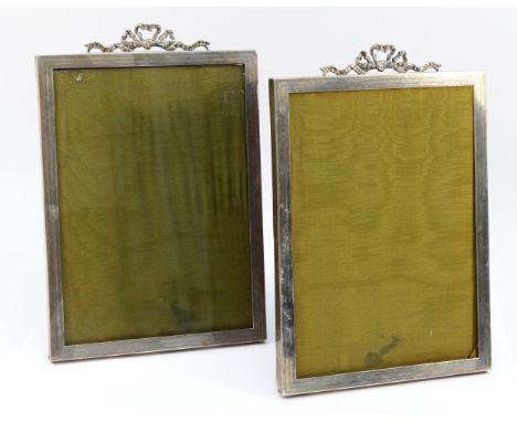 A pair of silver photograph frames, Birmingham 1926, with engine turned borders and cast scroll surmount, oak back and easel,